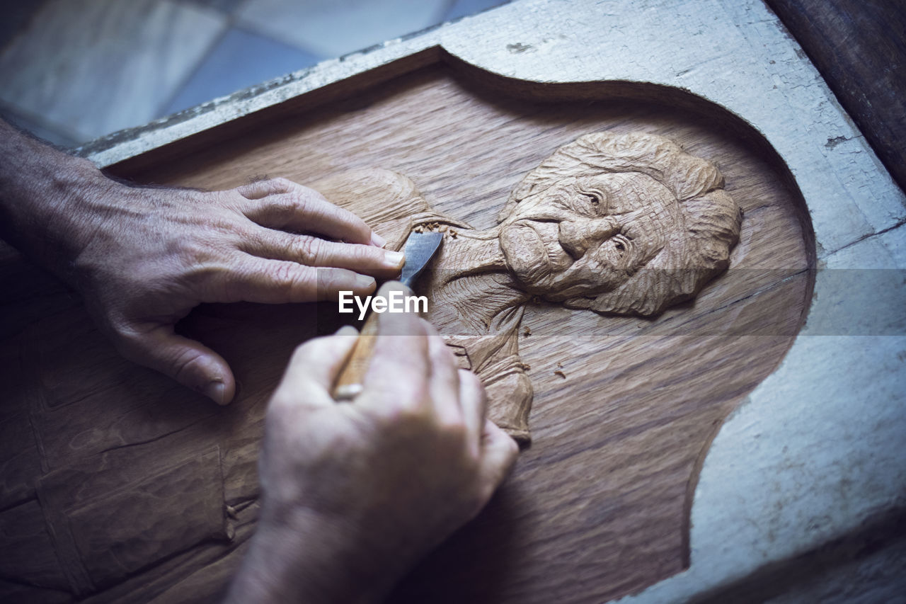 Cropped image of man carving in workshop