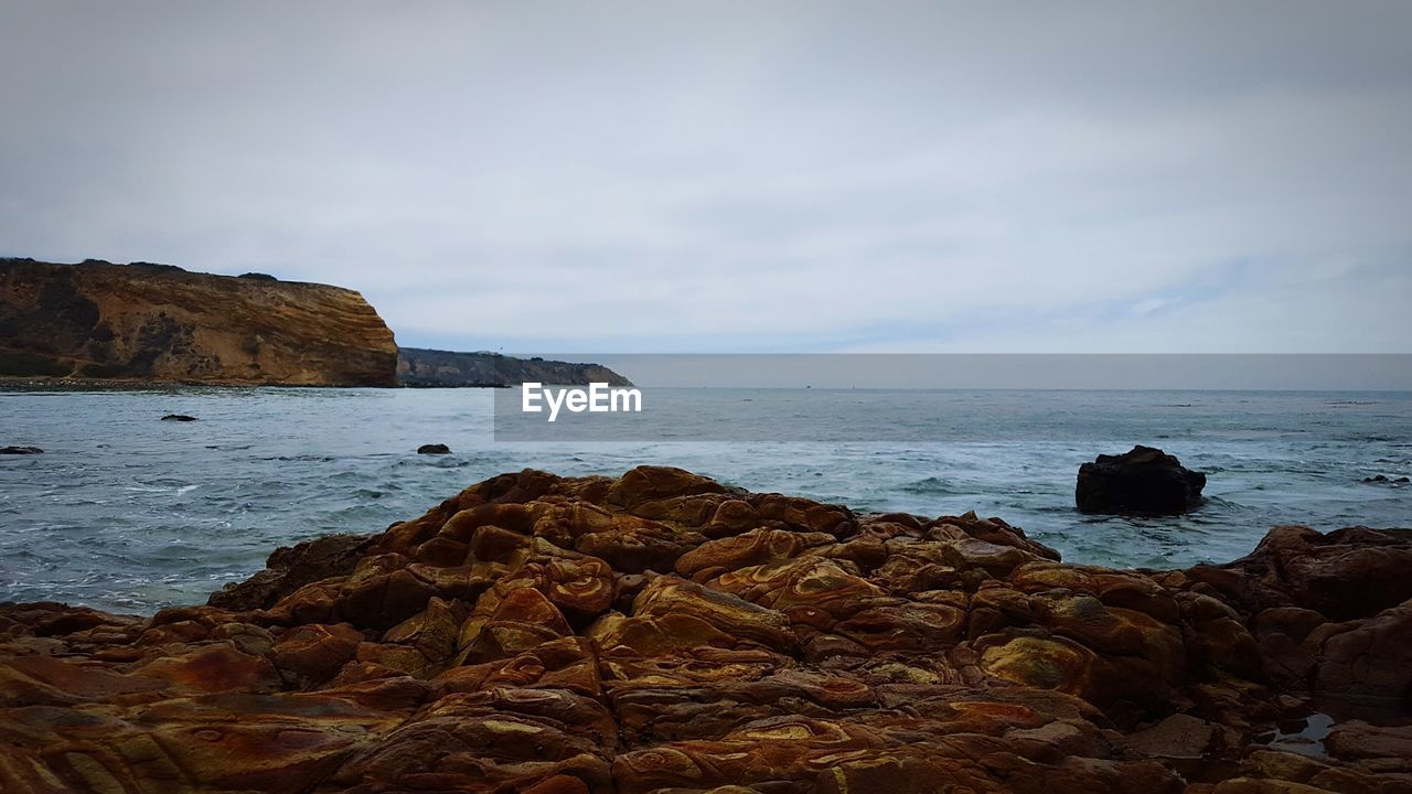 SCENIC VIEW OF SEA WITH ROCKS IN BACKGROUND