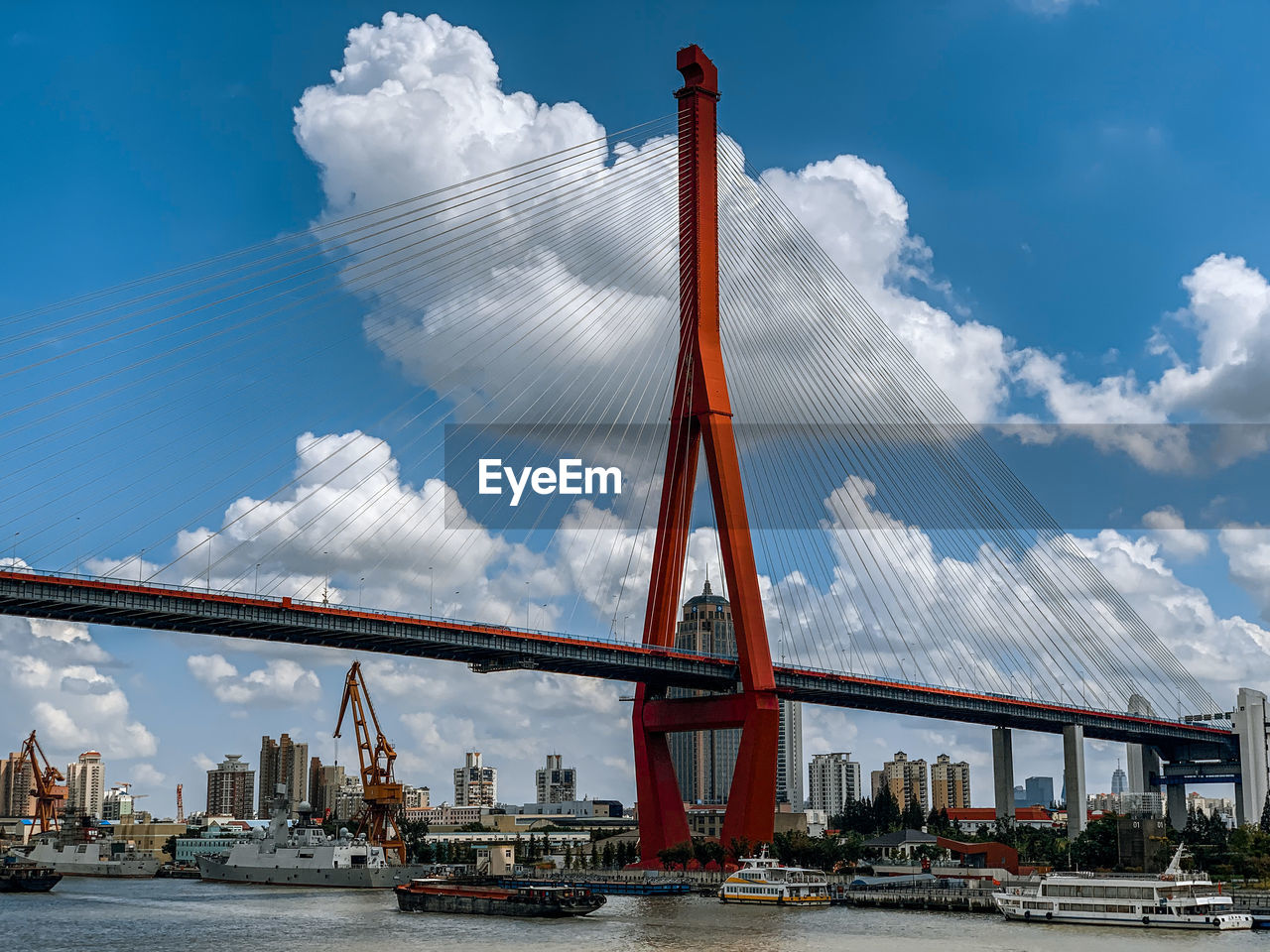 Panoramic view of suspension bridge against cloudy sky