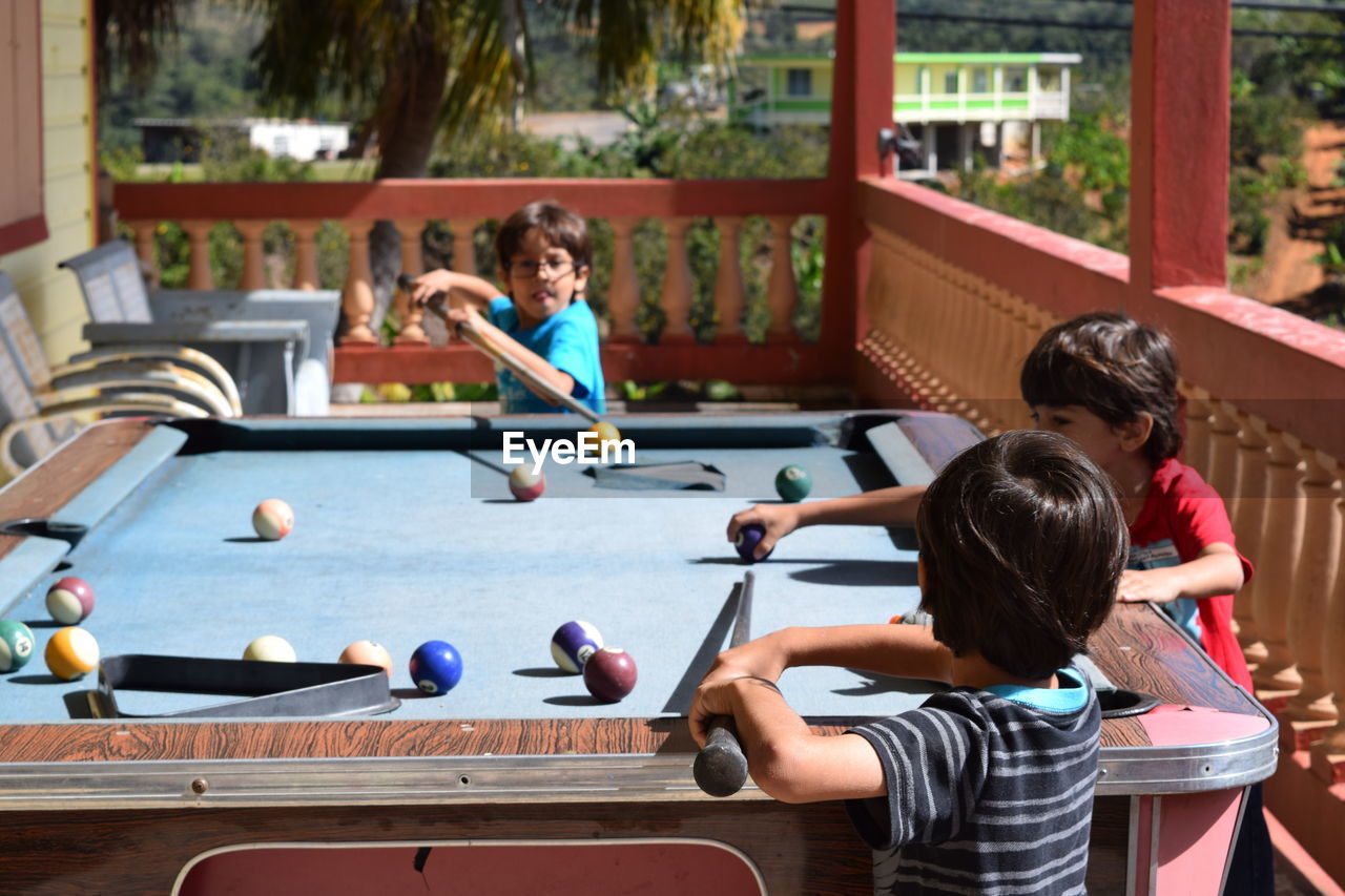 Cute children playing pool at porch