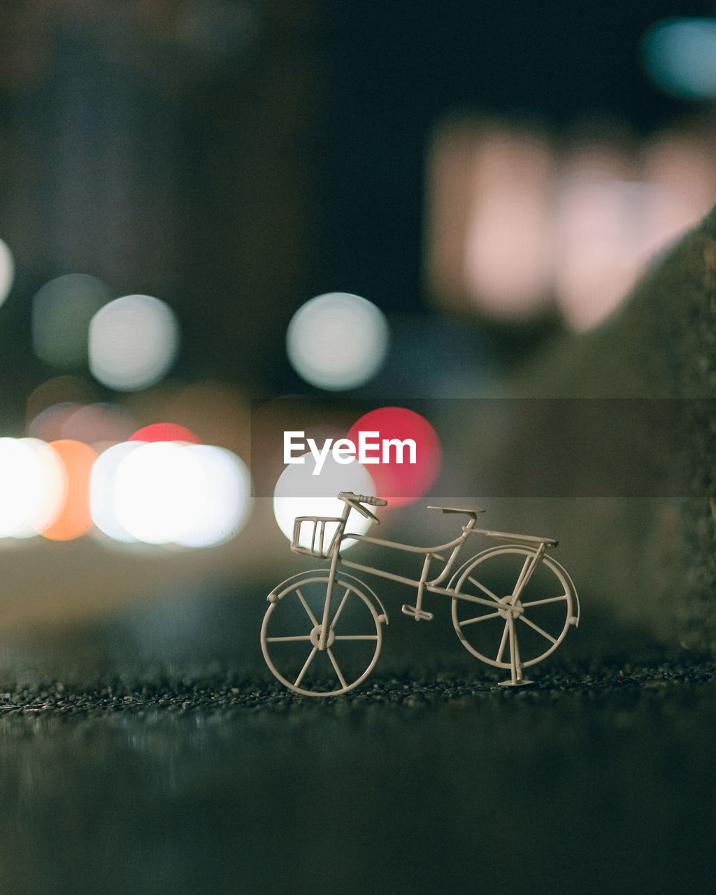bicycle, light, transportation, darkness, mode of transportation, no people, night, city, blue, vehicle, black, circle, land vehicle, street, outdoors, selective focus, illuminated, architecture, focus on foreground, close-up