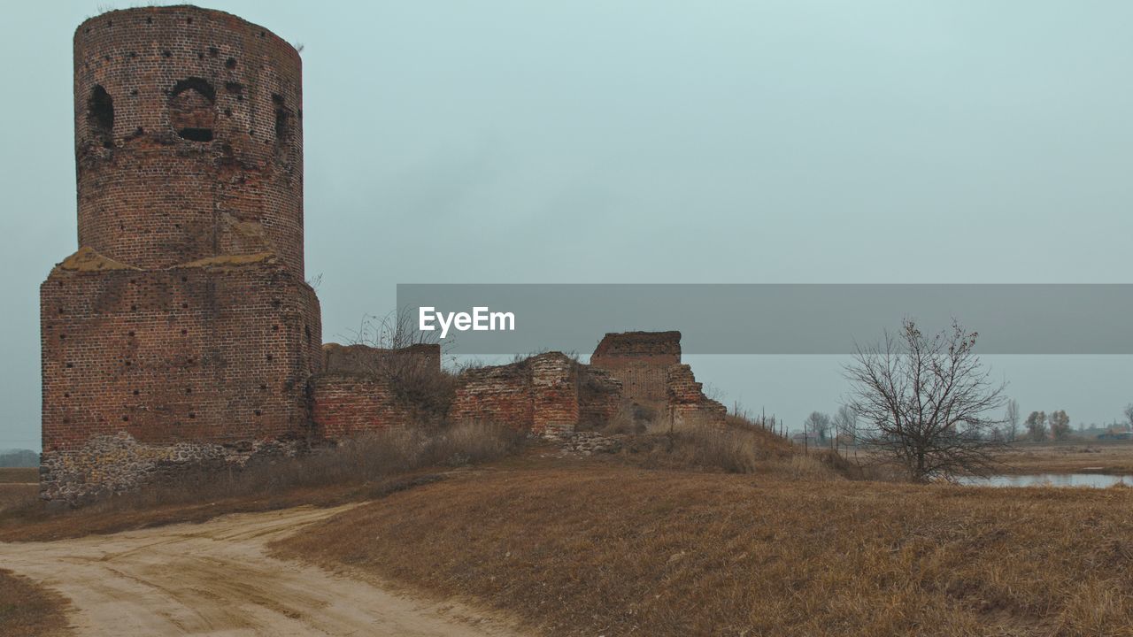 OLD RUIN BUILDING ON FIELD AGAINST SKY