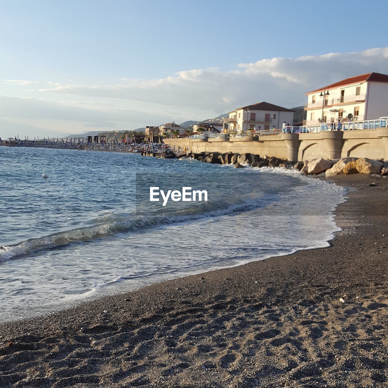 SCENIC VIEW OF BEACH BY BUILDINGS AGAINST SKY