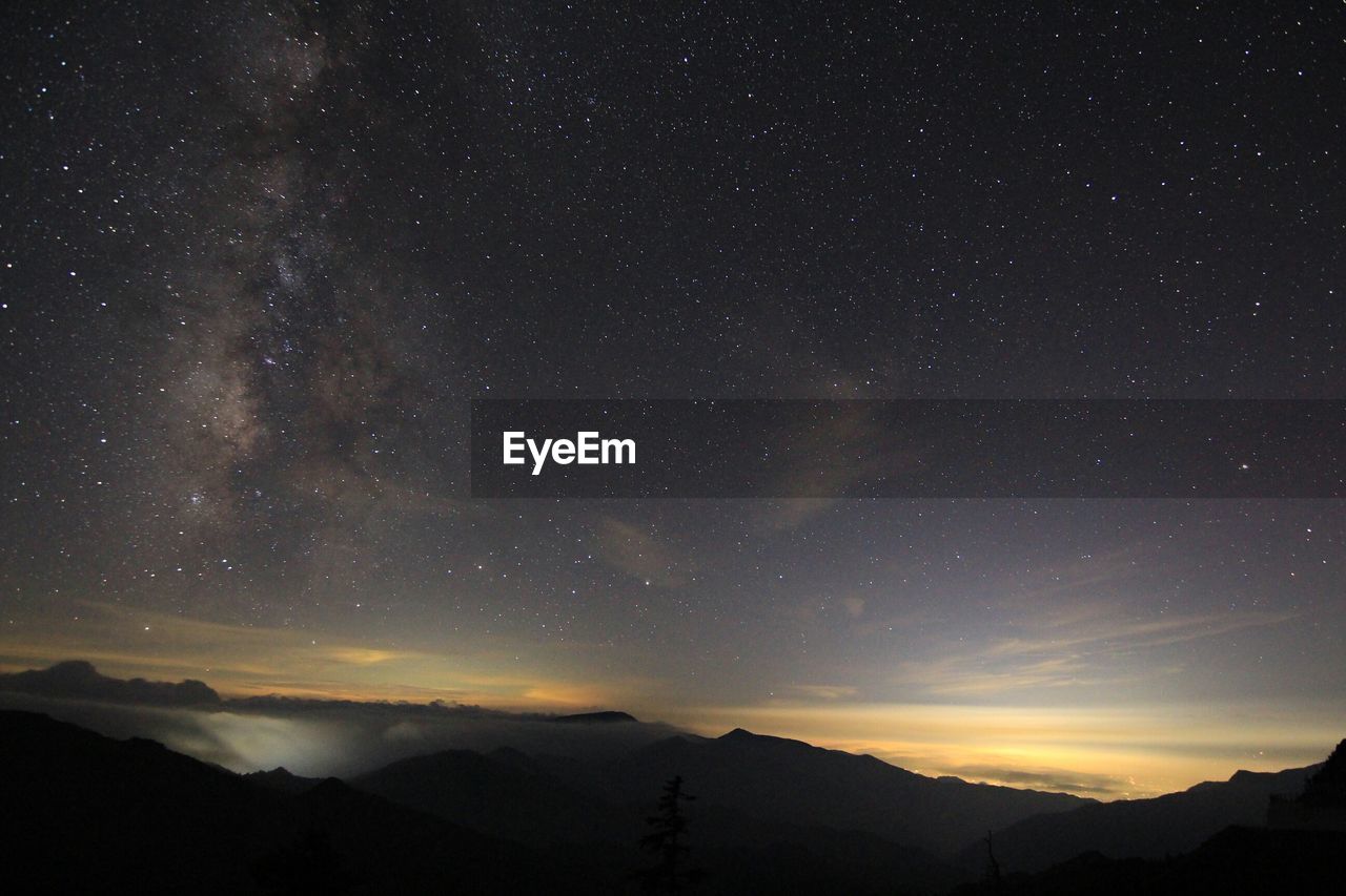 Silhouette landscape against starry sky