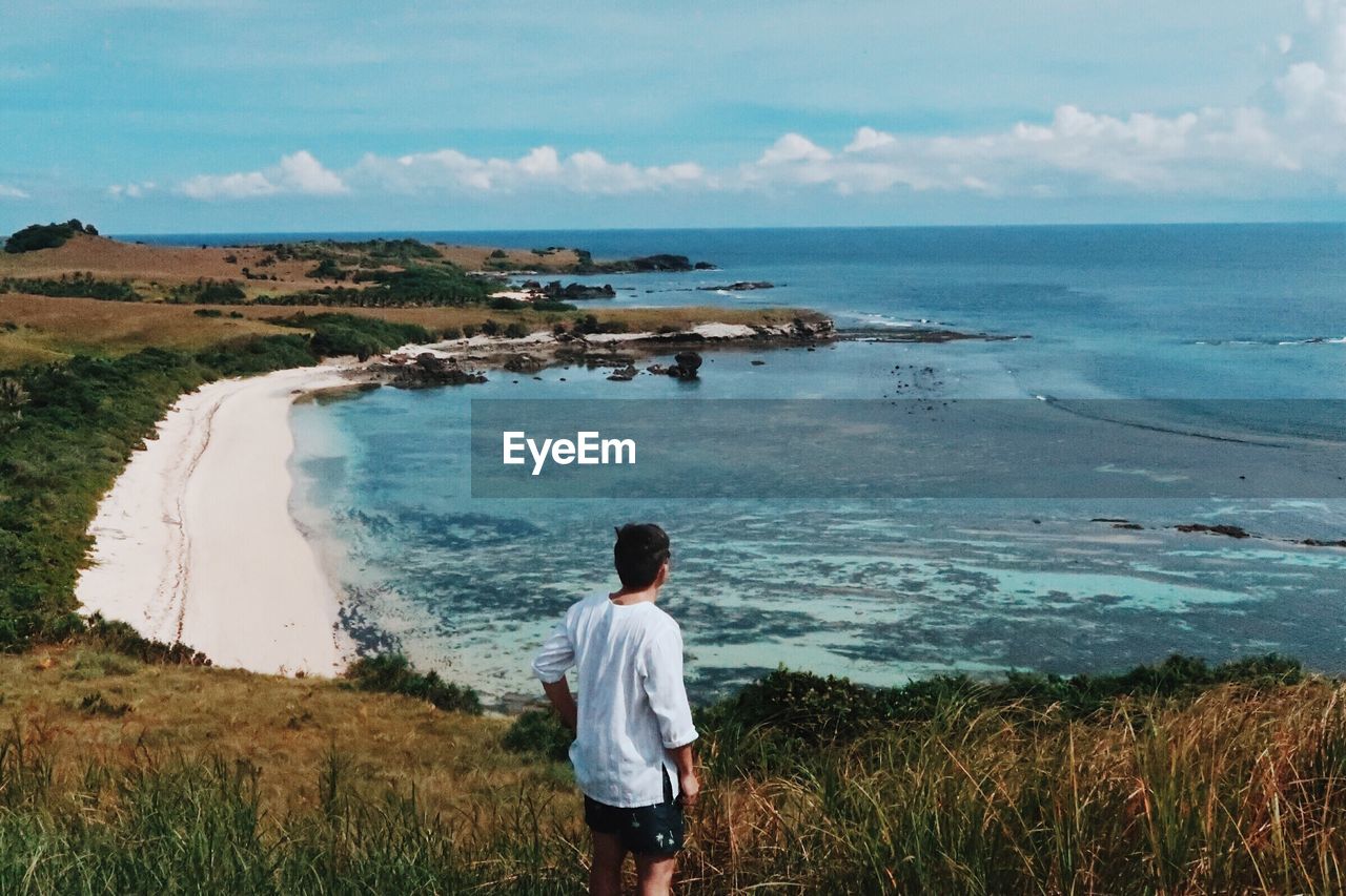 Rear view of man standing against sea