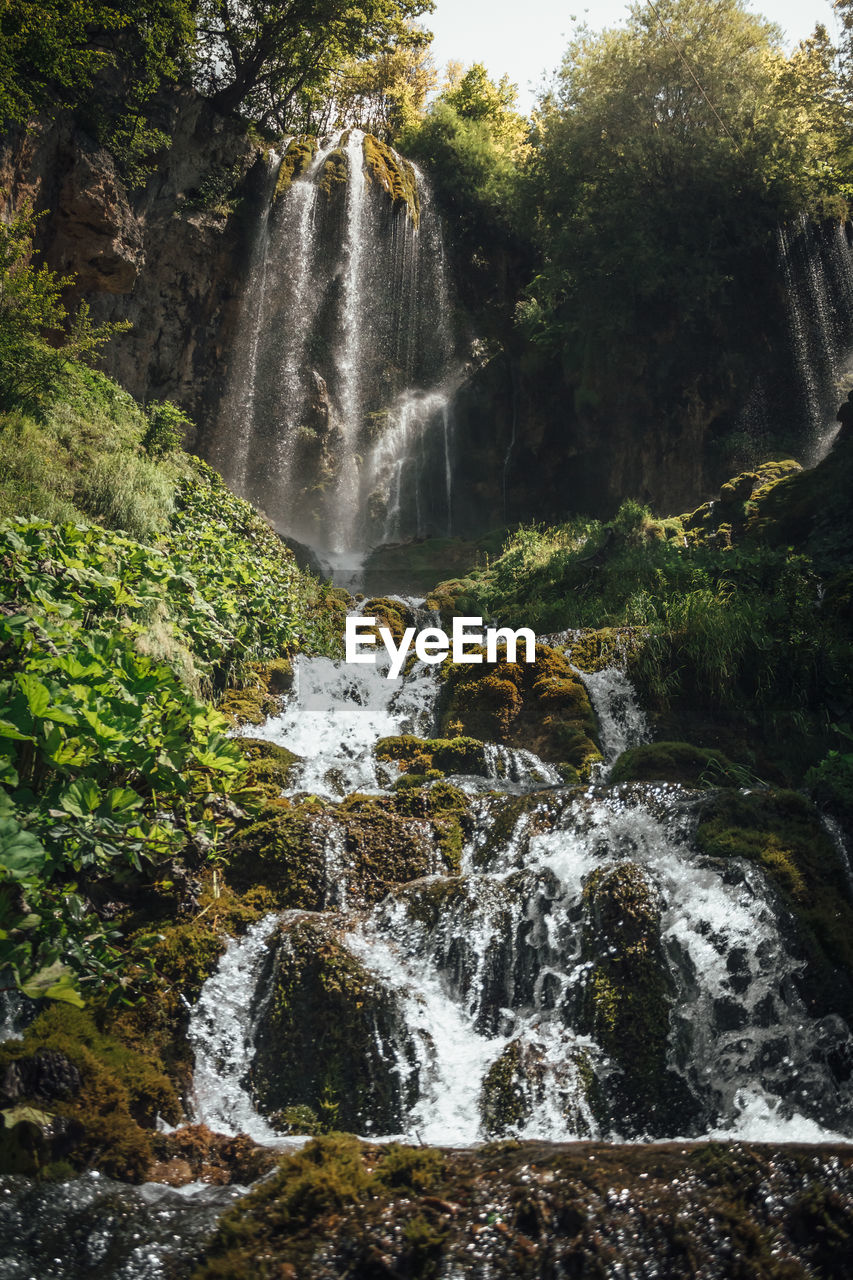 Waterfall in green deep woods, beautiful clean water, background