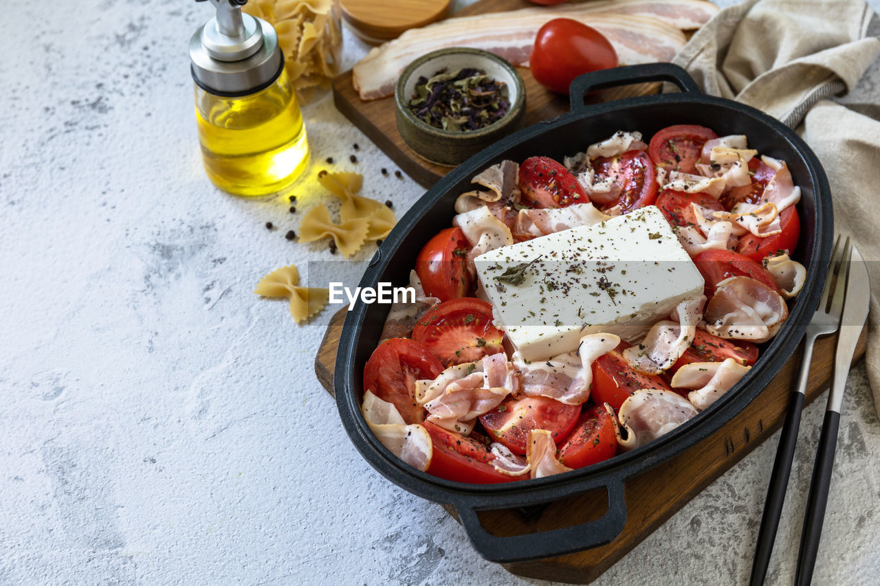 Ingredient for baked feta pasta, or tiktok pasta. oven baked feta pasta made of tomatoes, feta. 