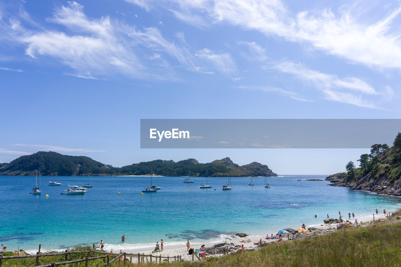 Panoramic view of people on beach against sky in nosa señora beach, in cíes islands, vigo, galicia,  