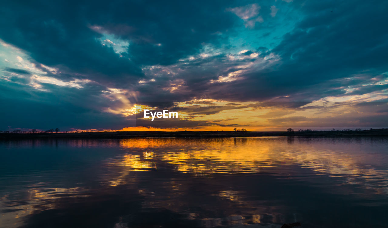 Scenic view of lake against dramatic sky