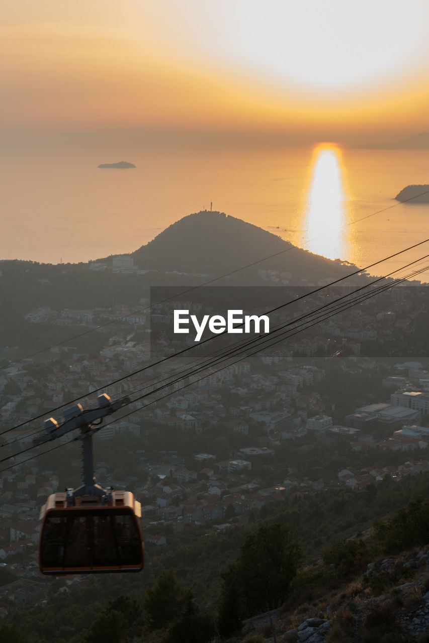 OVERHEAD CABLE CAR OVER SEA AGAINST SKY