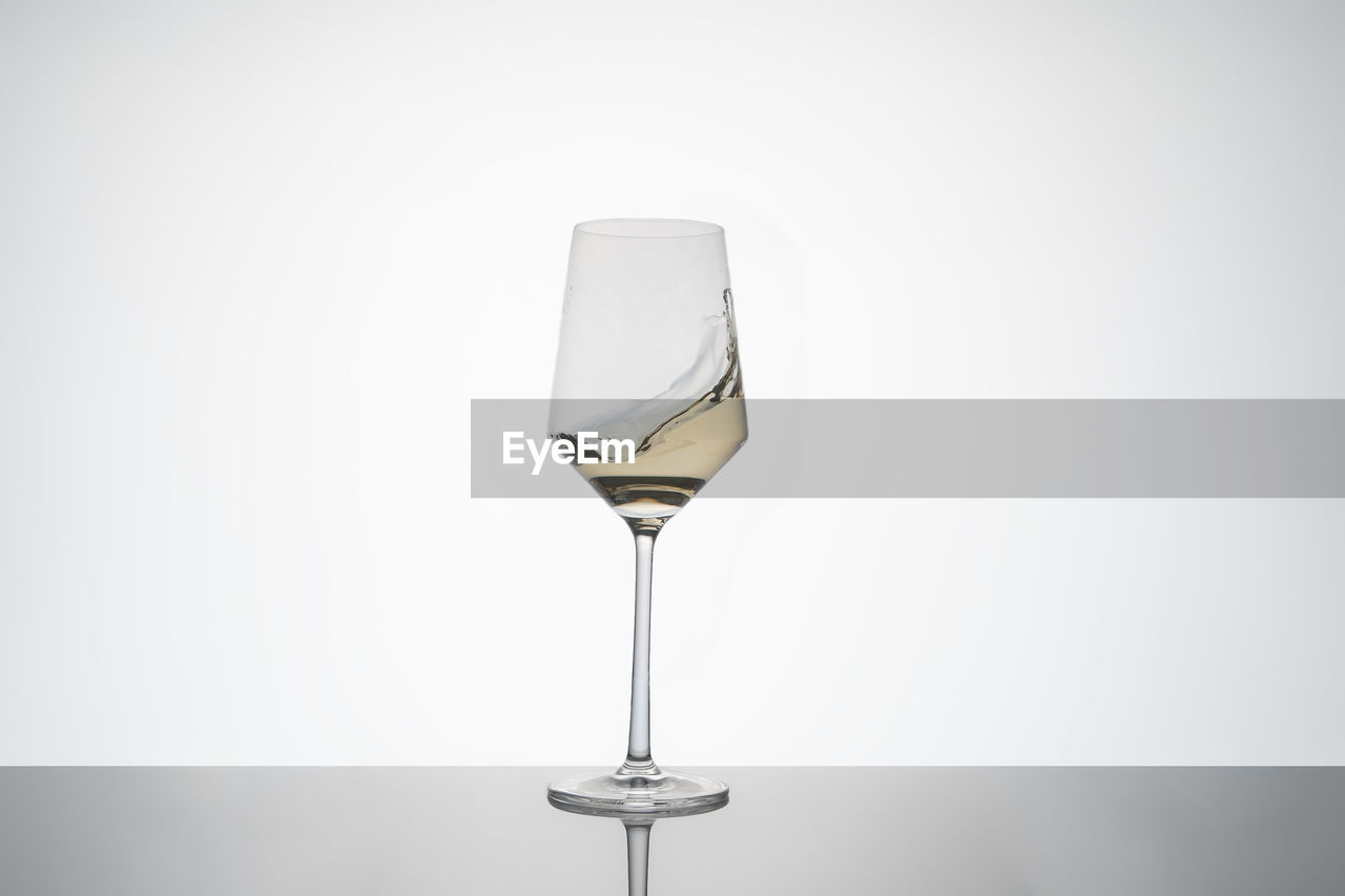 glass, refreshment, drink, alcohol, food and drink, drinkware, champagne stemware, stemware, wine glass, drinking glass, studio shot, wine, household equipment, indoors, copy space, no people, alcoholic beverage, transparent, gray background, reflection, still life, single object, white background, gray, tableware, simplicity, freshness
