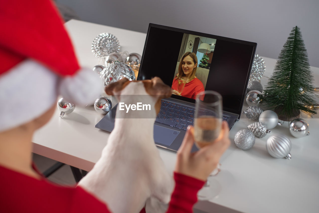 Cropped hand of woman using laptop on table