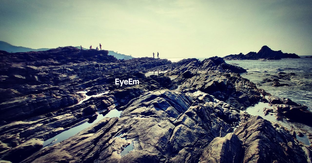 AERIAL VIEW OF ROCKS ON SHORE AGAINST SKY