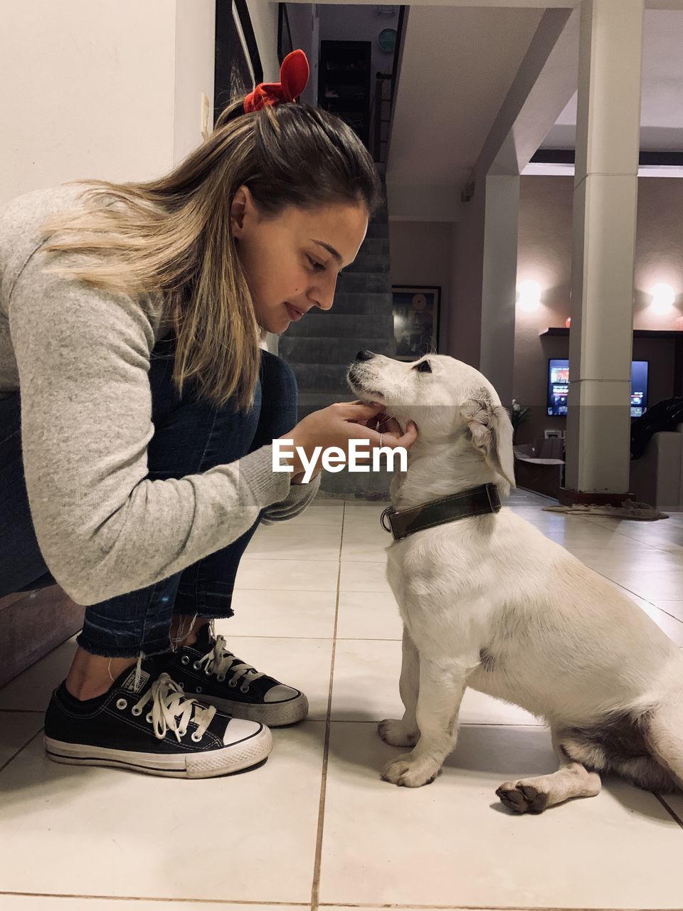 Woman with dog sitting at home