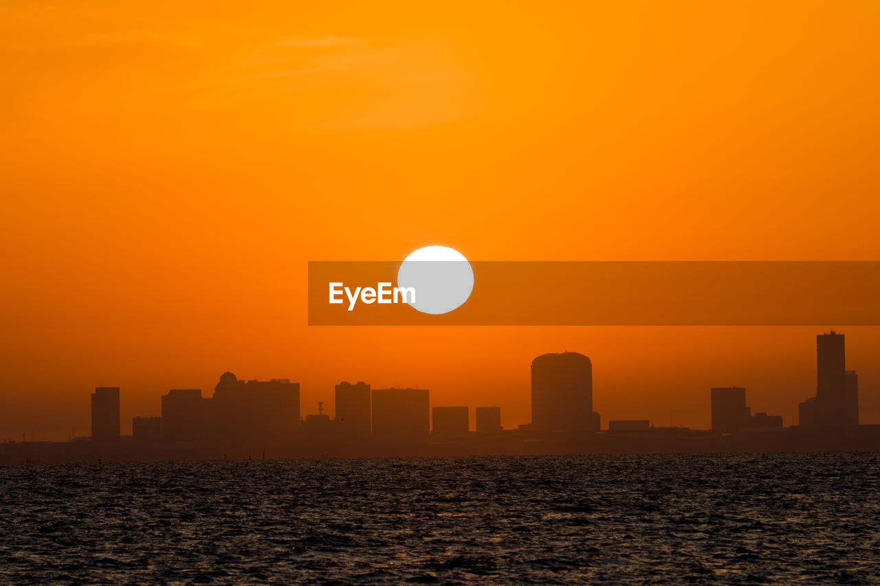 Scenic view of sea against orange sky during sunrise