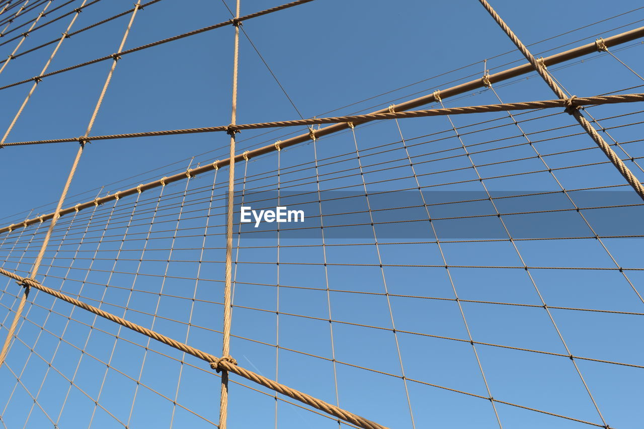 Low angle view of bridge cables against clear sky