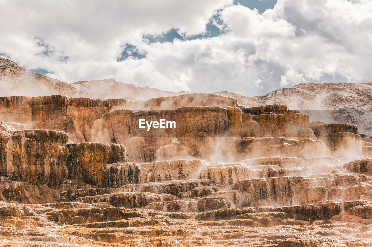 Panoramic view of rocks on landscape against cloudy sky