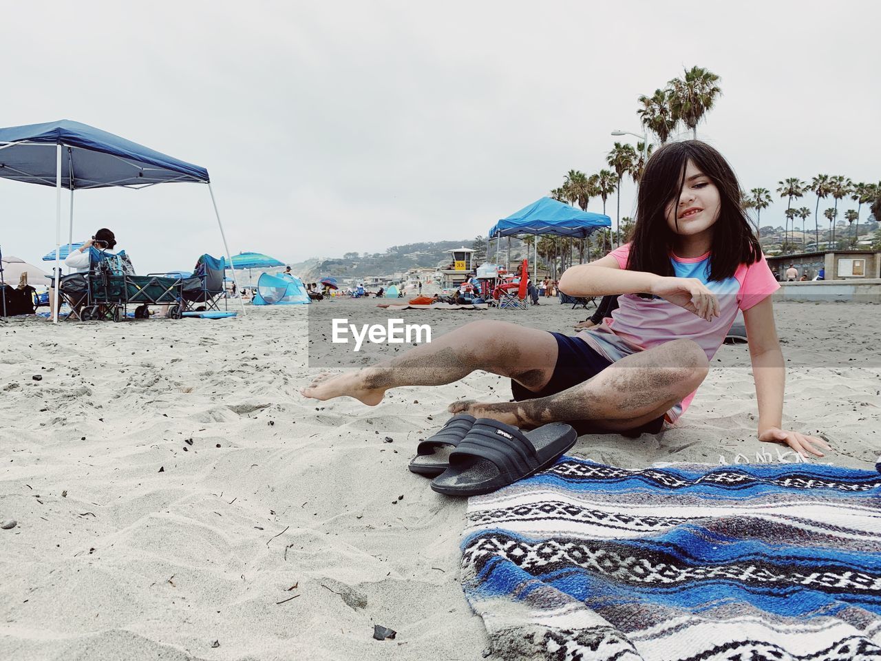 WOMAN SITTING ON BEACH