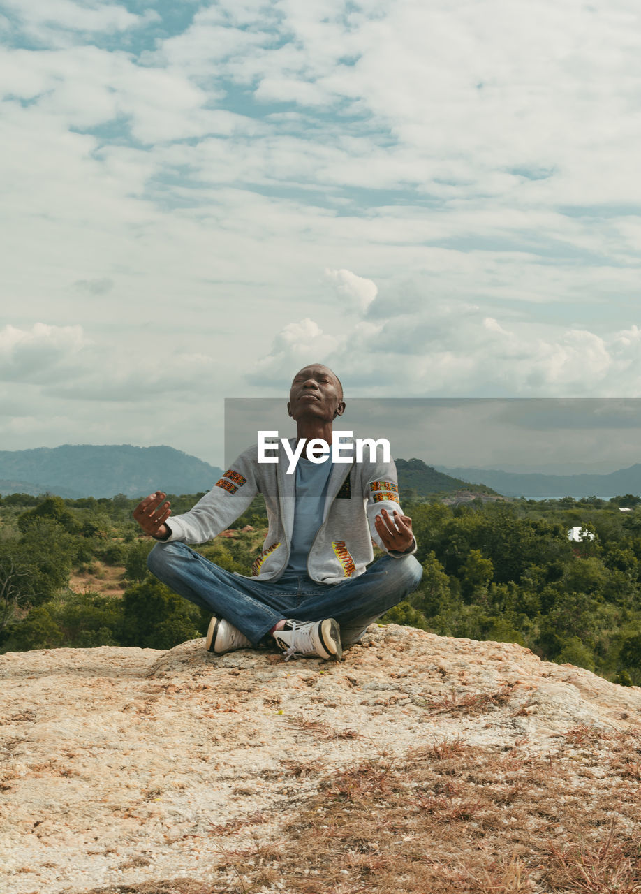 A man sitting on a hill top meditating