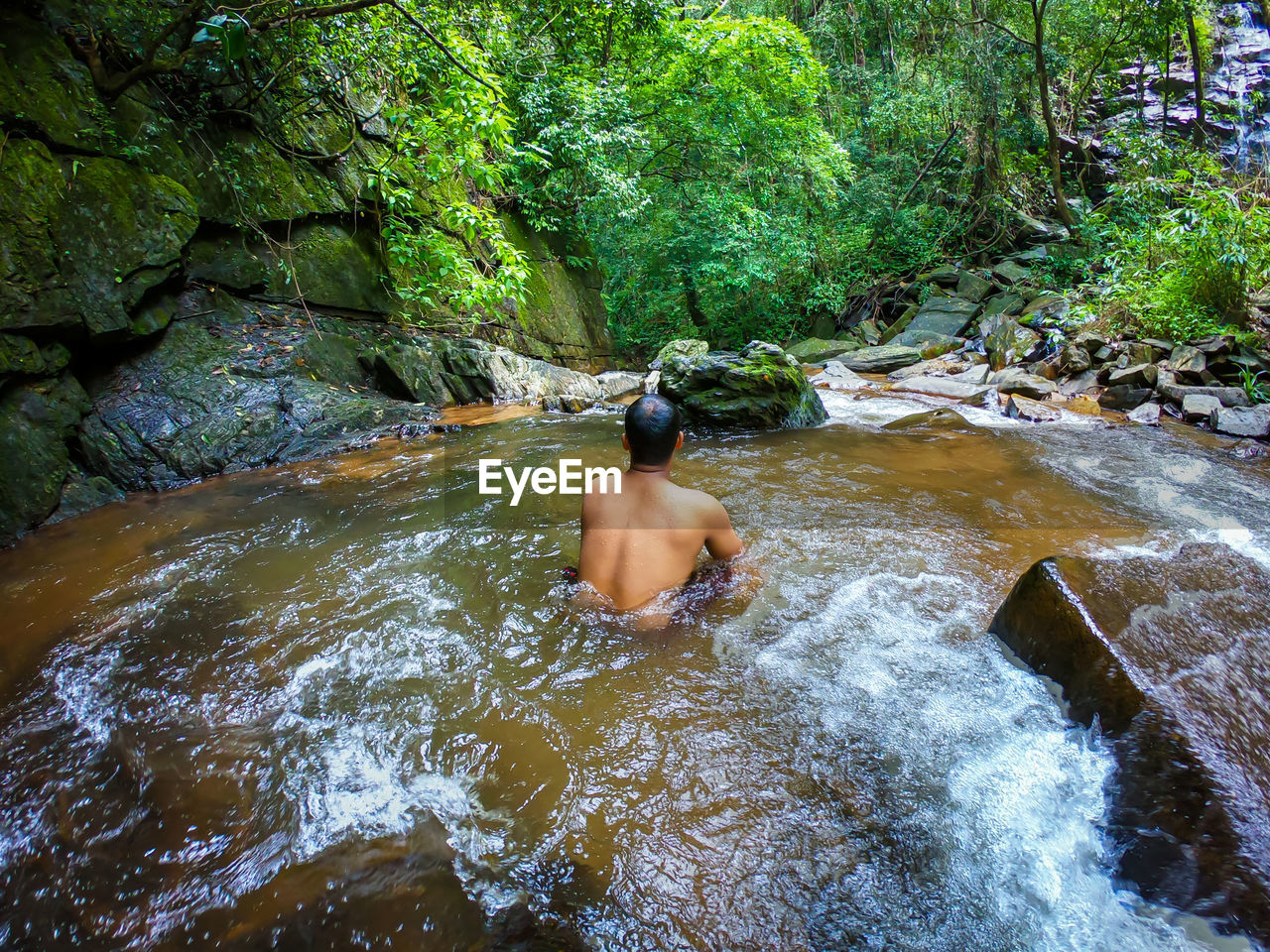 Man in silence in natural waterfall in green forests from different angle