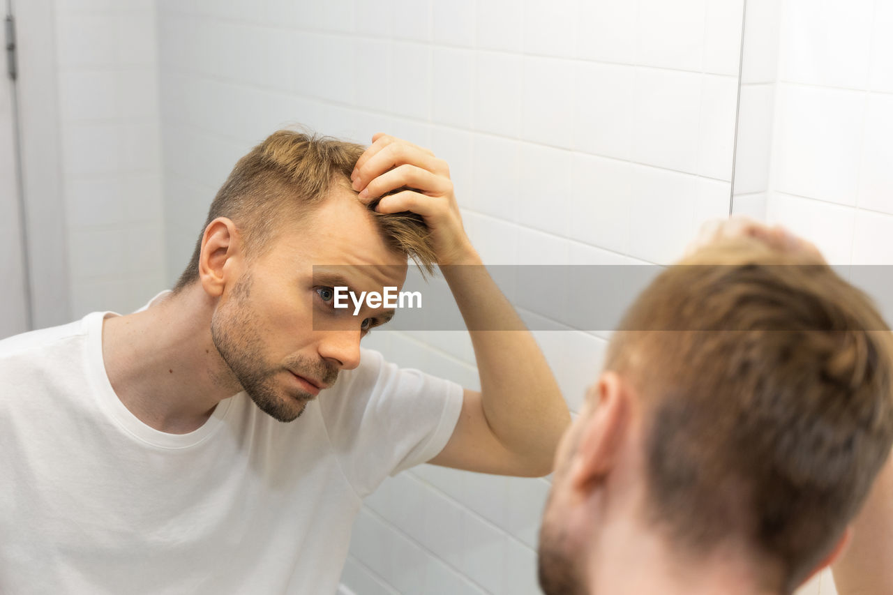 men, bathroom, adult, indoors, domestic bathroom, two people, human hair, young adult, home, domestic room, lifestyles, human face, person, hairstyle, headshot, body care, mirror, emotion, hygiene, sadness, beard, portrait, routine