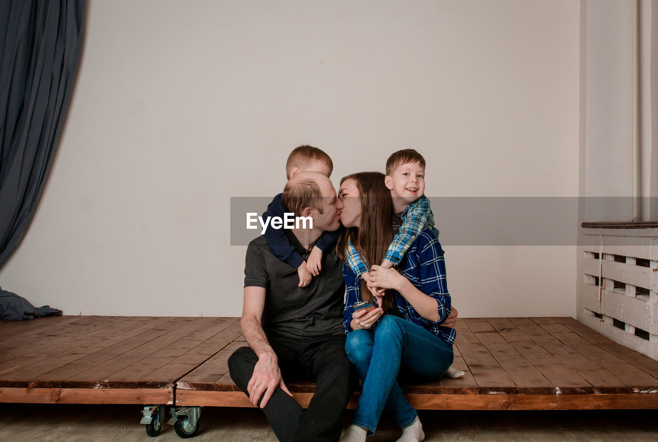 Mom and dad kiss in front of the children. young parents