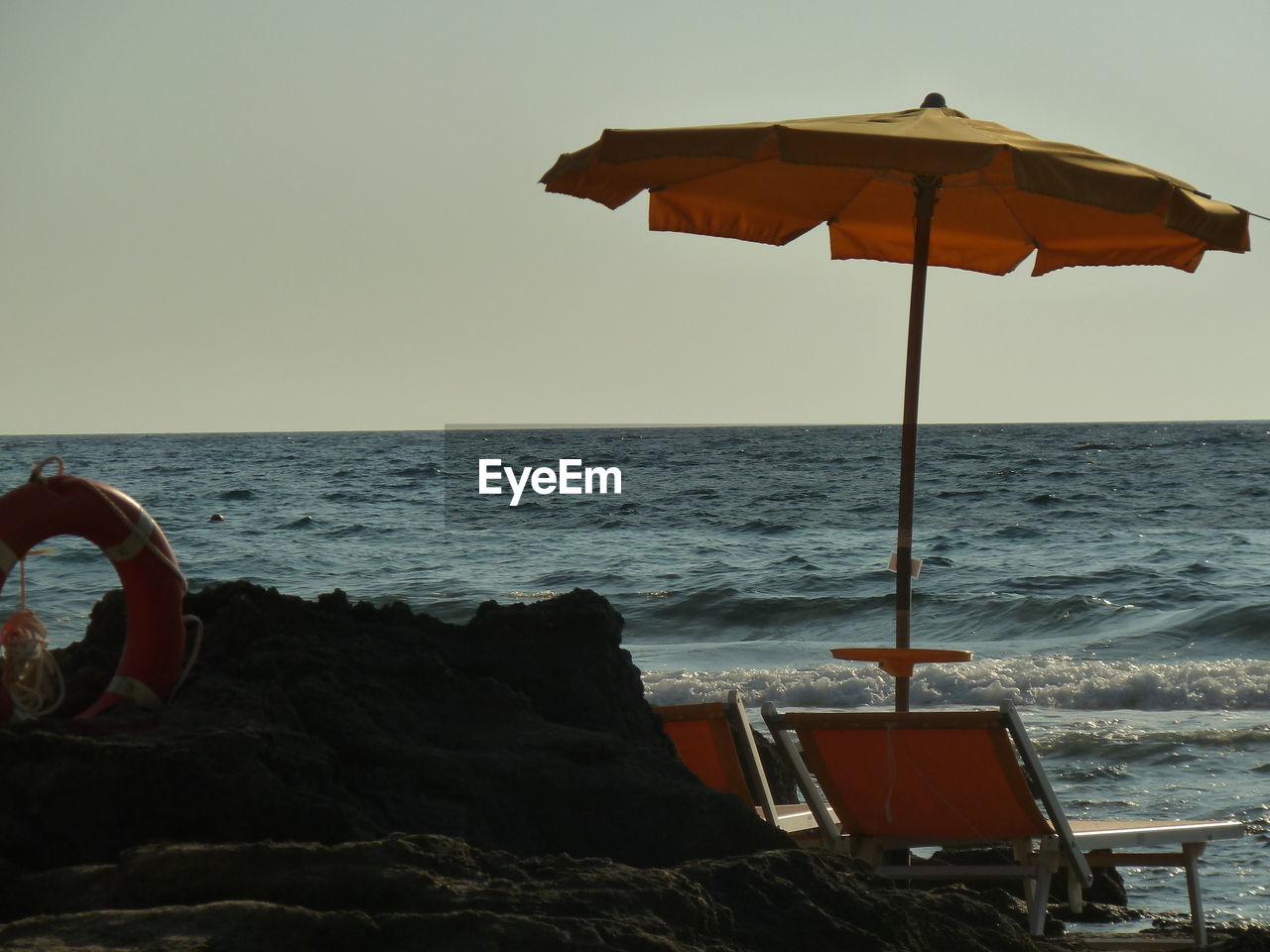 BEACH UMBRELLA ON SHORE AGAINST SEA