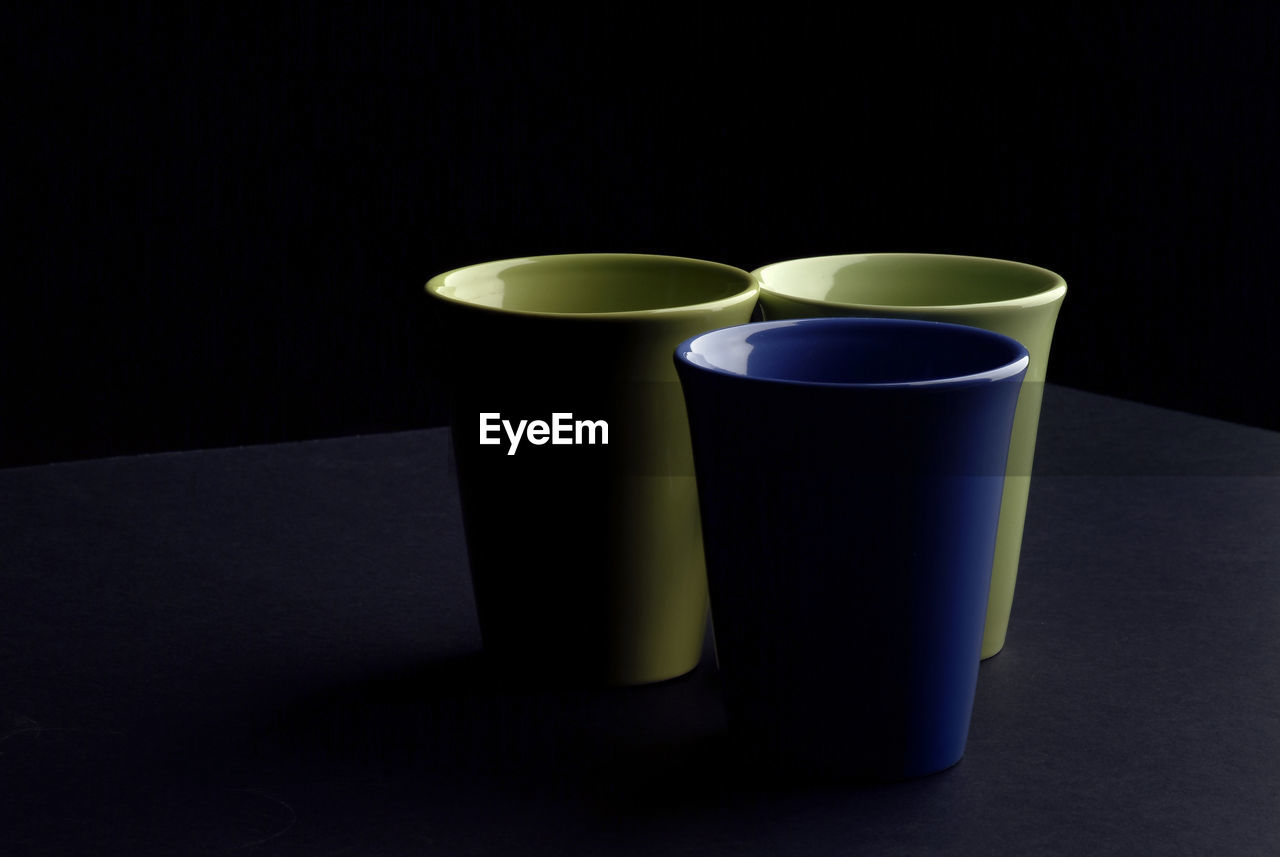 Close-up of empty coffee cups against black background