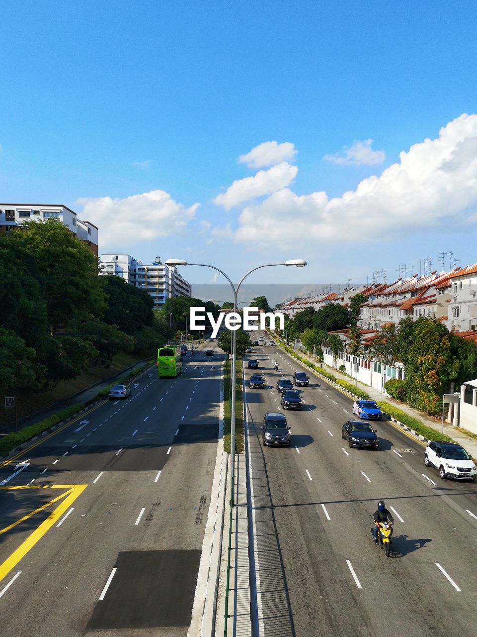 Vehicles on road in city against sky