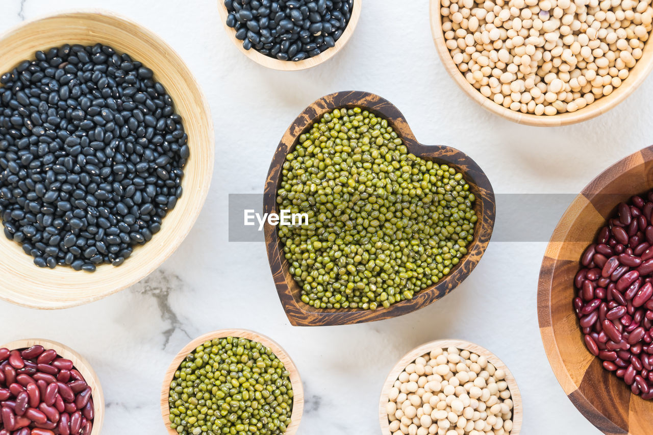 Directly above shot of various beans in bowls over white background