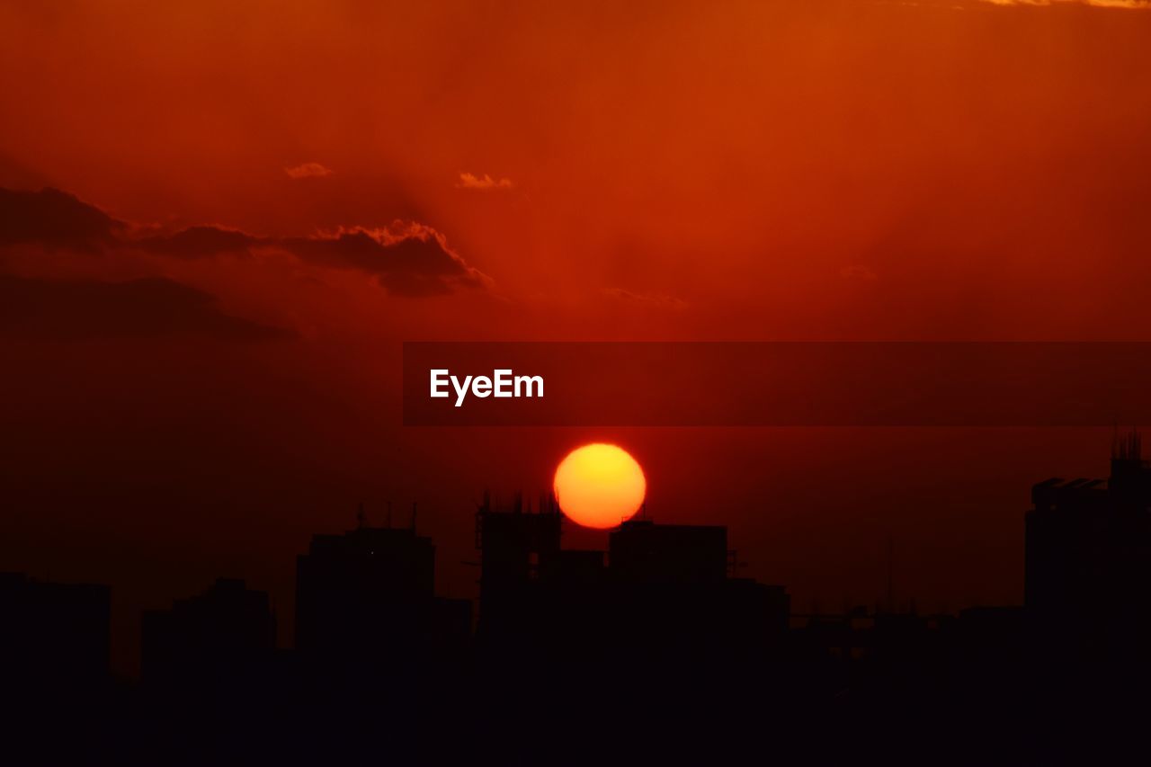 SILHOUETTE BUILDINGS AGAINST ORANGE SKY