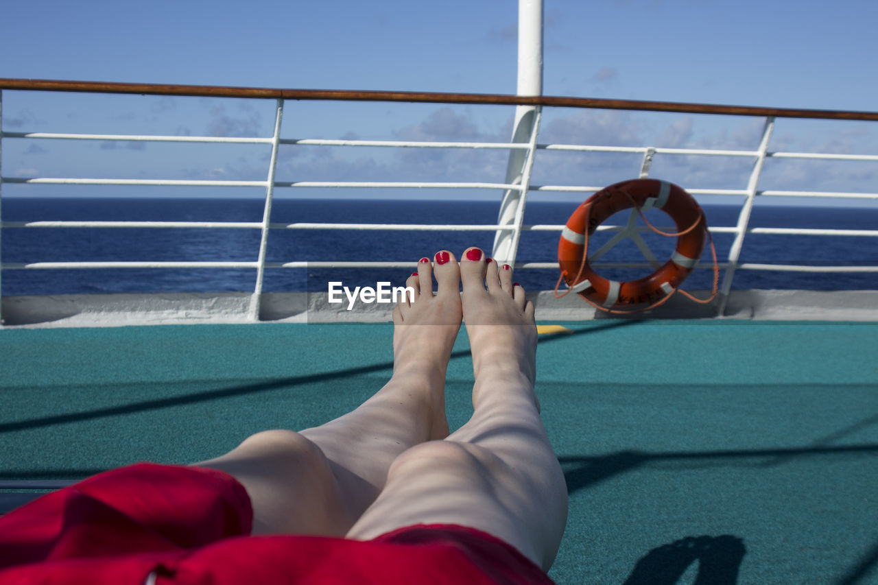 Low section of woman relaxing on deck
