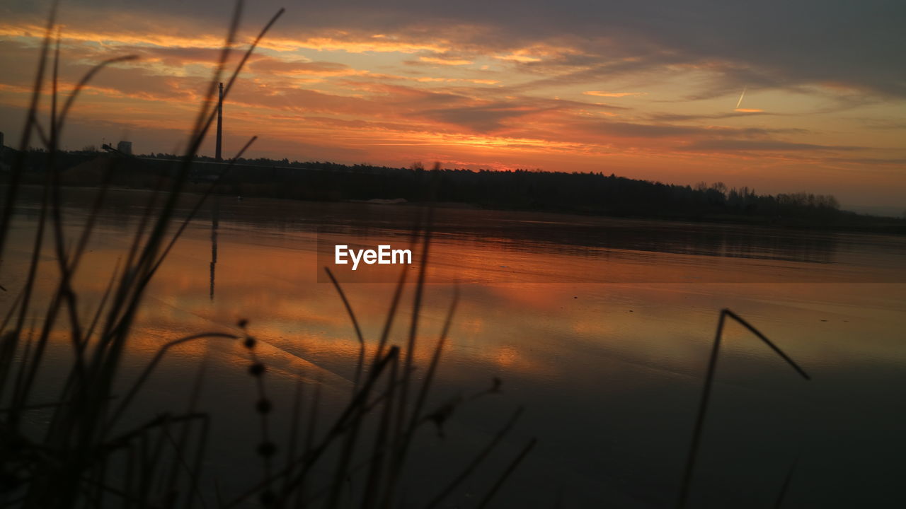 SCENIC VIEW OF LAKE AGAINST DRAMATIC SKY