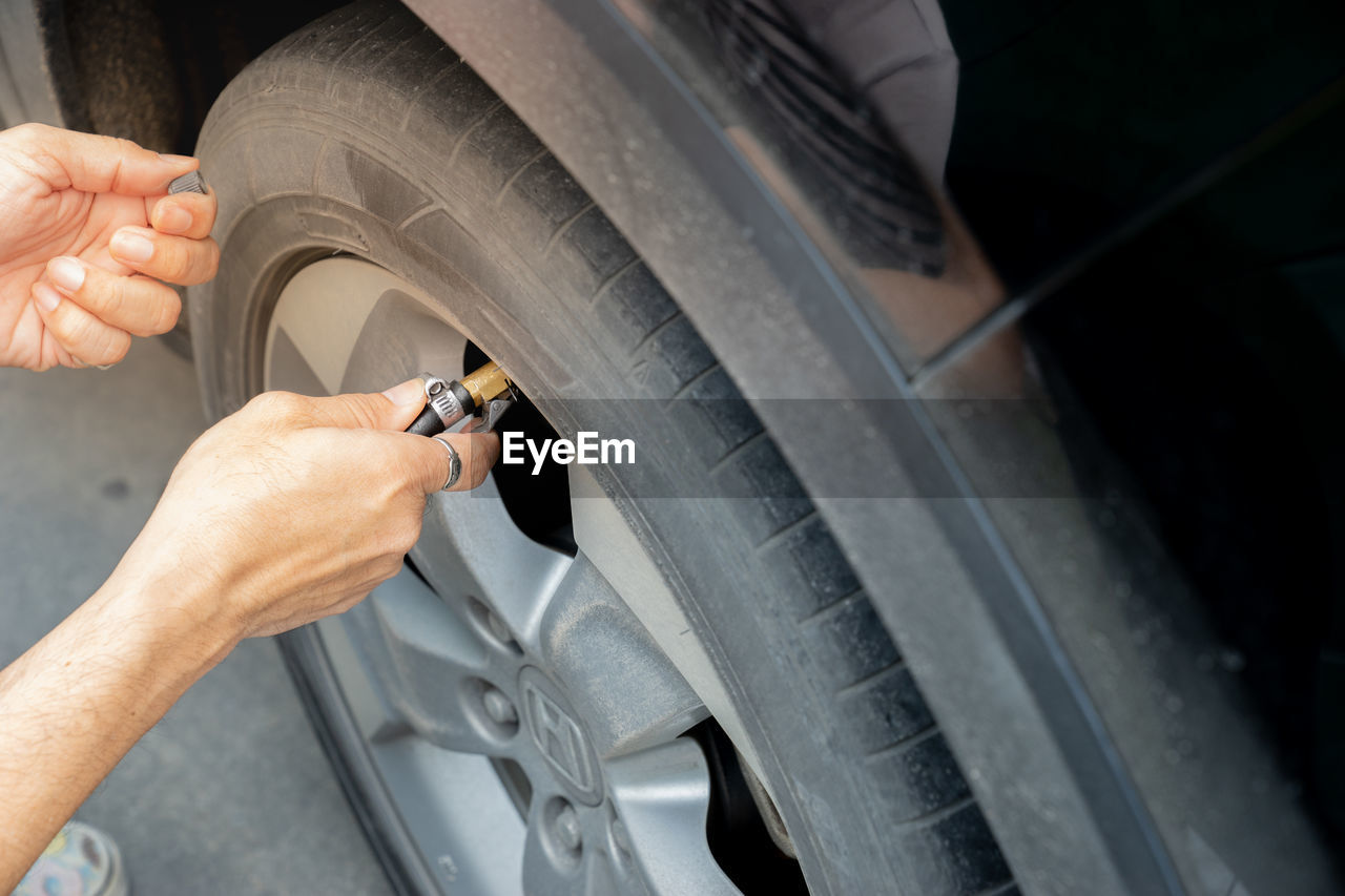 Cropped hand of woman tightening car wheel