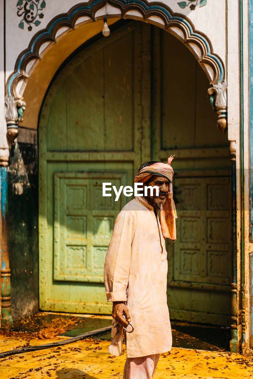 WOMAN STANDING BY DOOR OF BUILDING