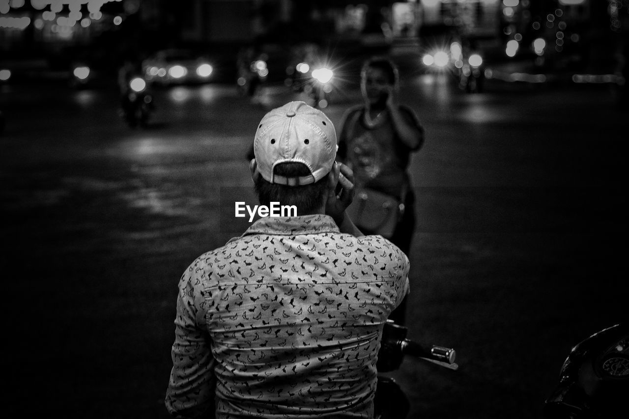 Rear view of man on street at night