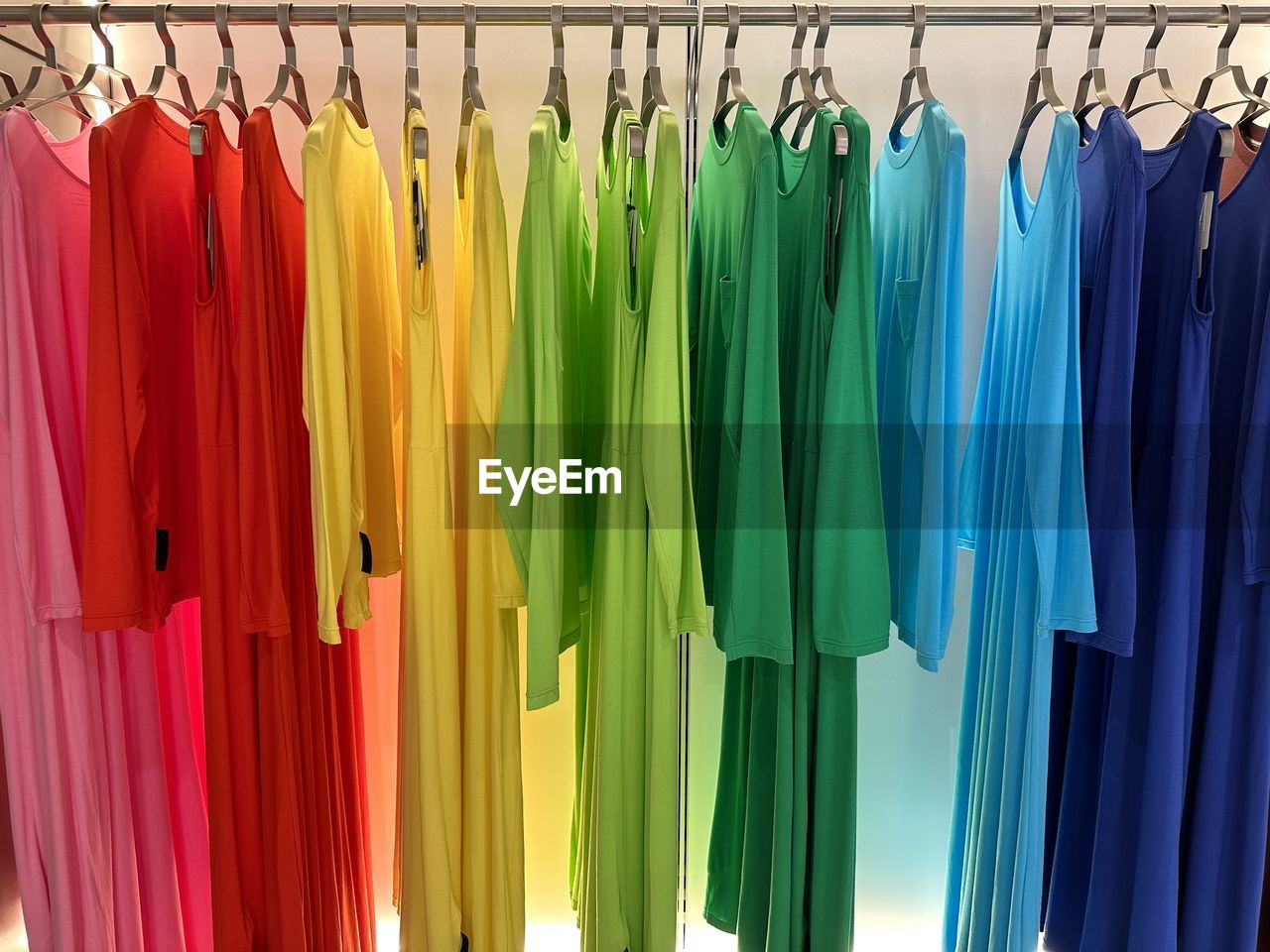 multi colored, hanging, variation, clothing, coathanger, large group of objects, no people, retail, store, in a row, fashion, rack, shopping, business, indoors, clothes rack, green, abundance, textile, side by side, vibrant color