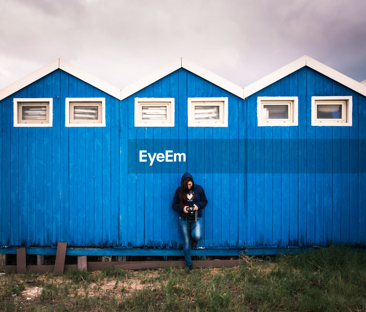 Photographer checking photos resting behind a sea hut