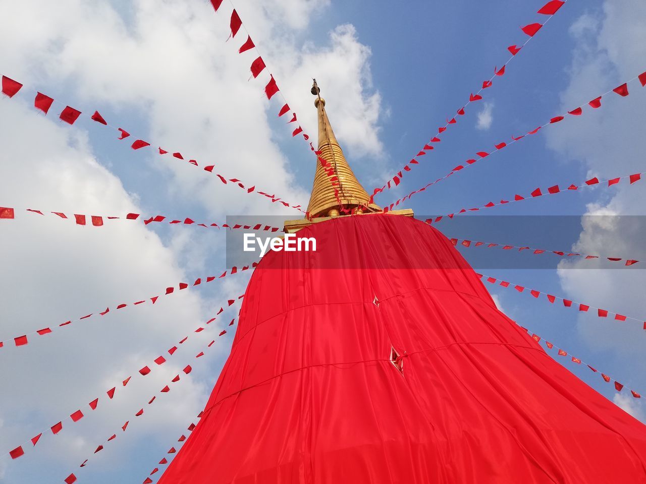 LOW ANGLE VIEW OF RED UMBRELLA AGAINST SKY AT TEMPLE