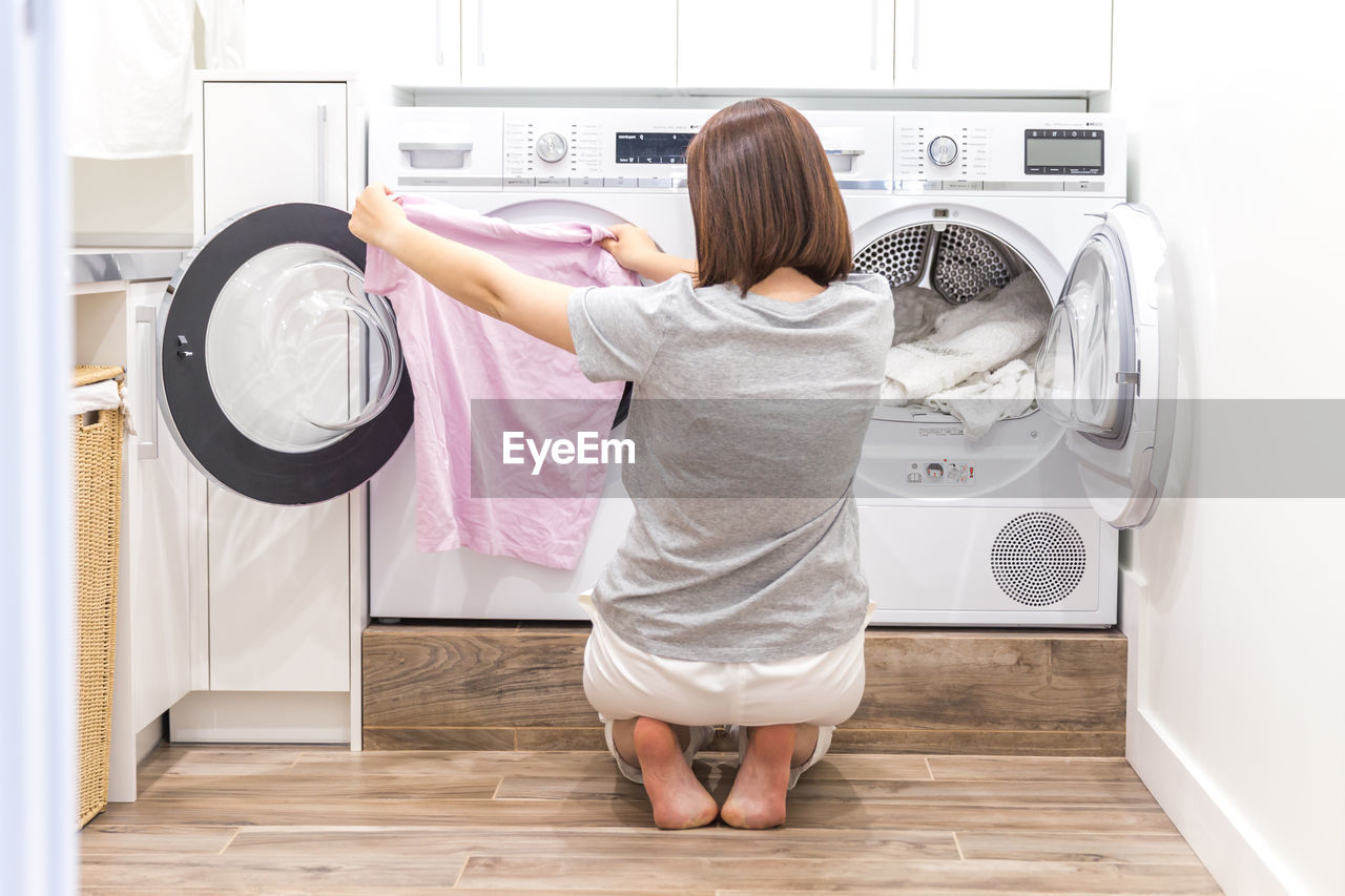 Woman removing clothes from washing machine