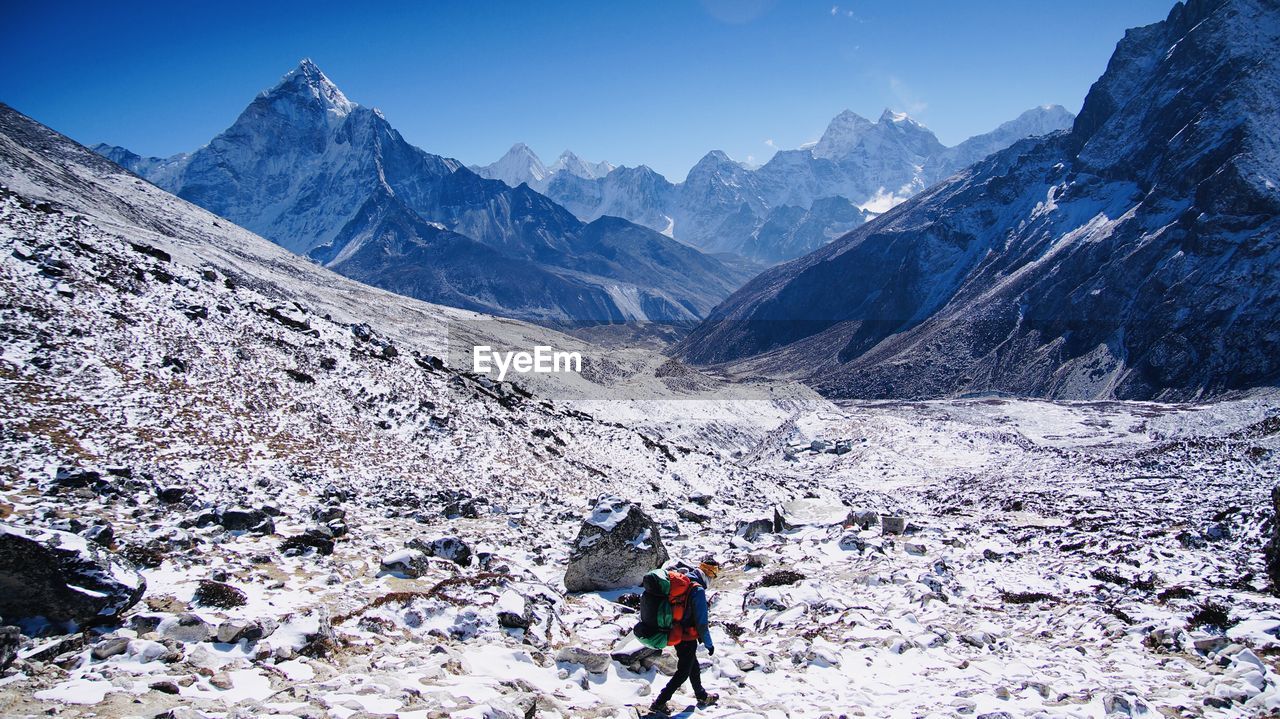 Rear view of person on snowcapped mountains during winter