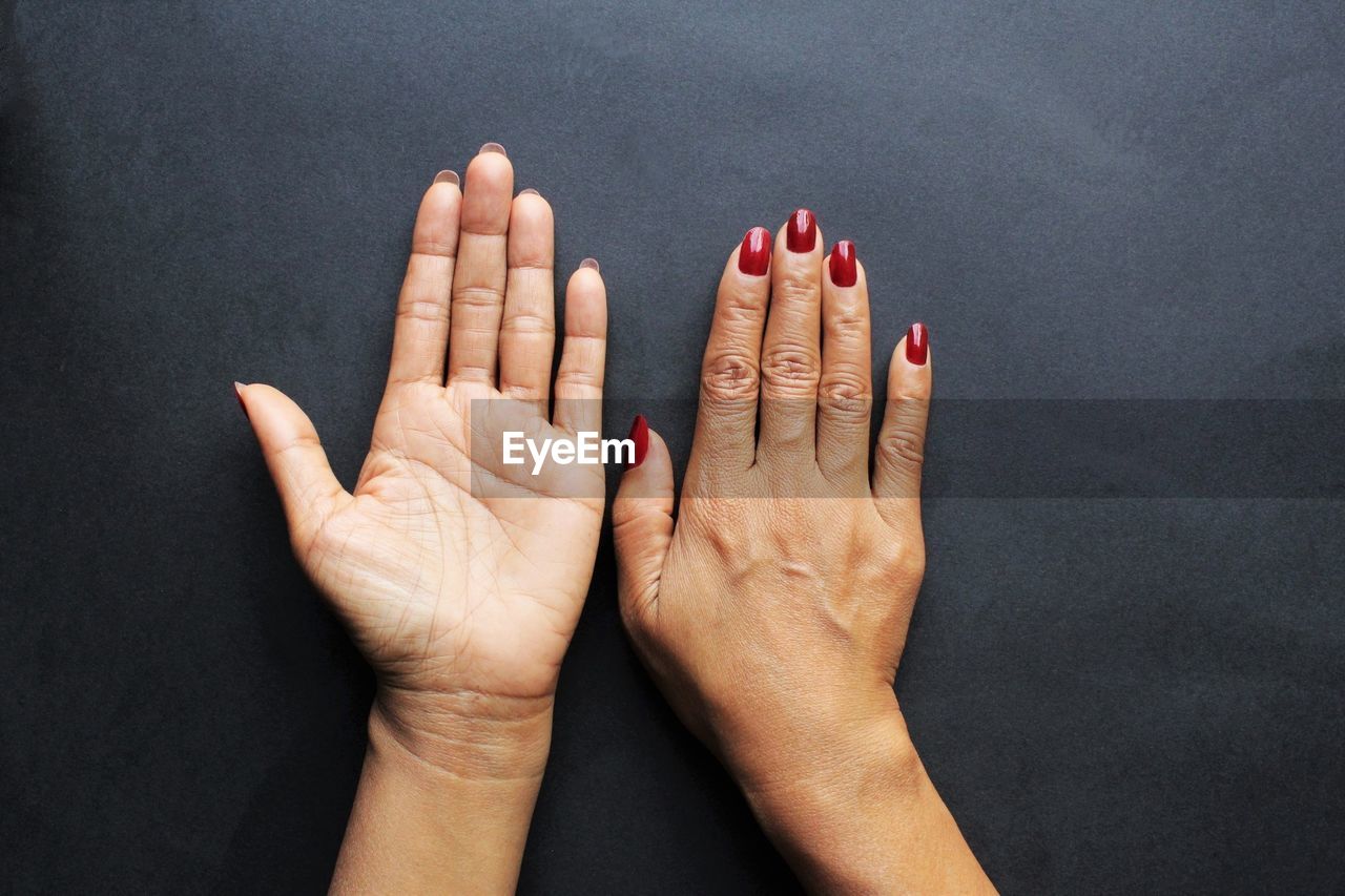 CLOSE-UP OF HAND AGAINST BLACK BACKGROUND