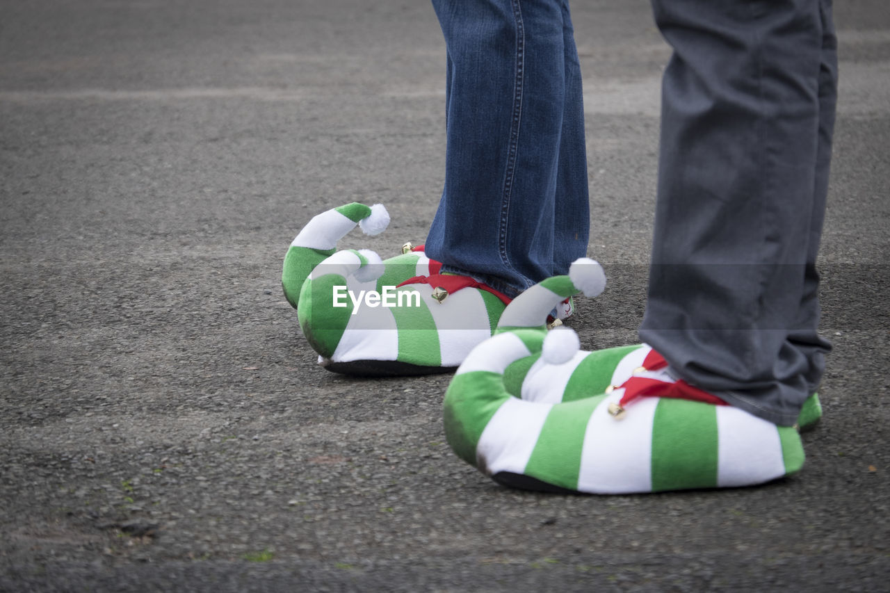 Low section of people wearing shoes while standing on road