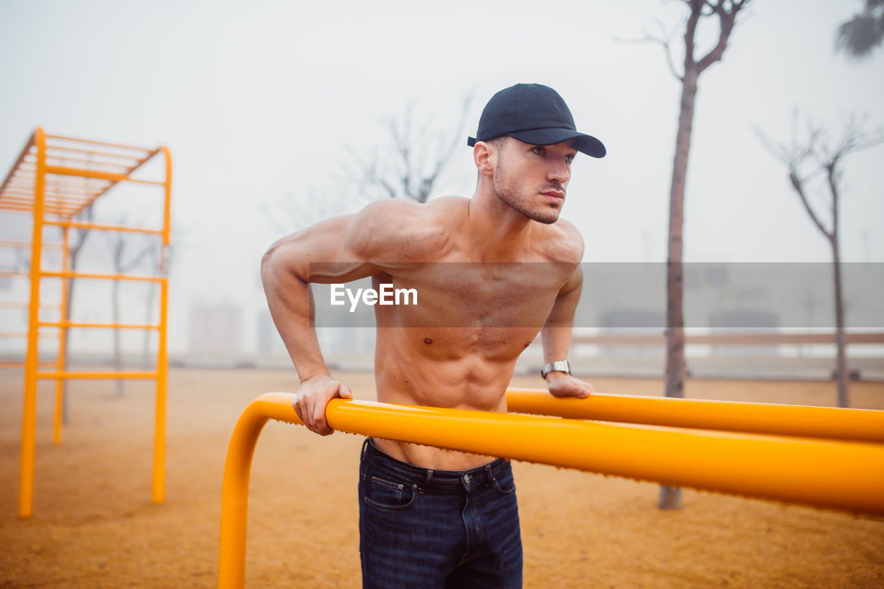 Athletic man doing exercises for triceps in a calisthenics park