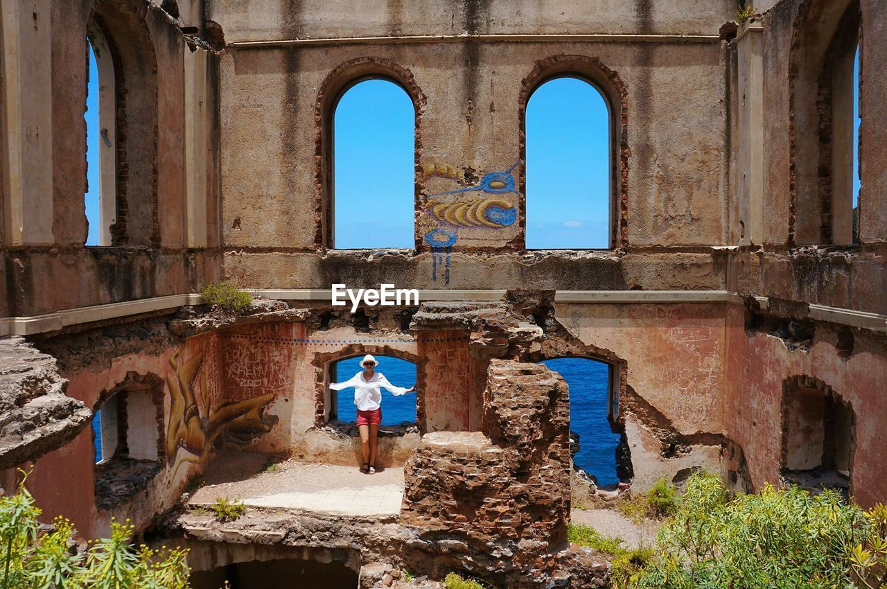 MAN STANDING AGAINST BUILDING