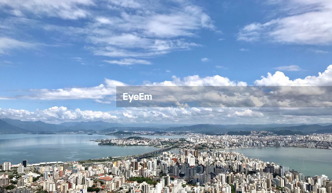 High angle view of city by sea against sky