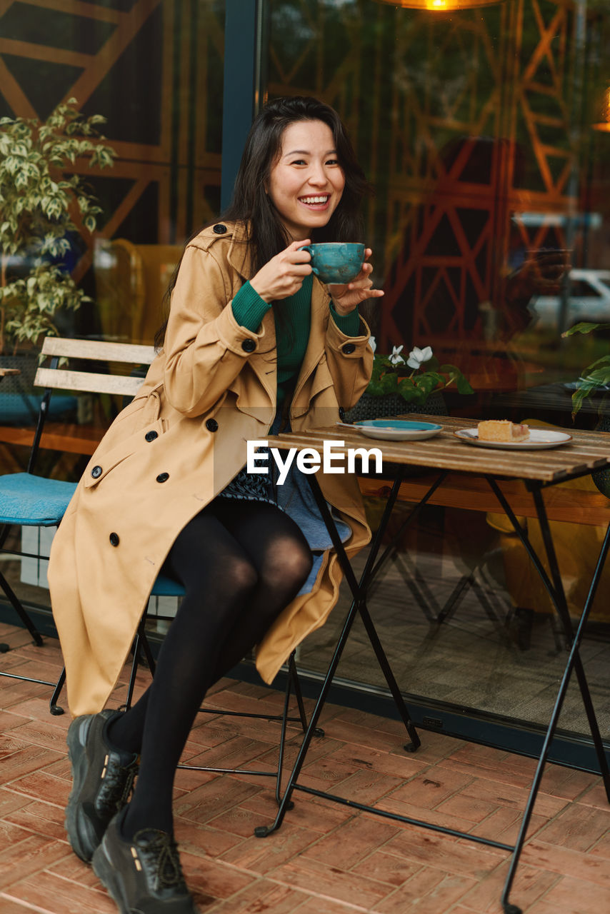 portrait of young woman sitting on chair at park