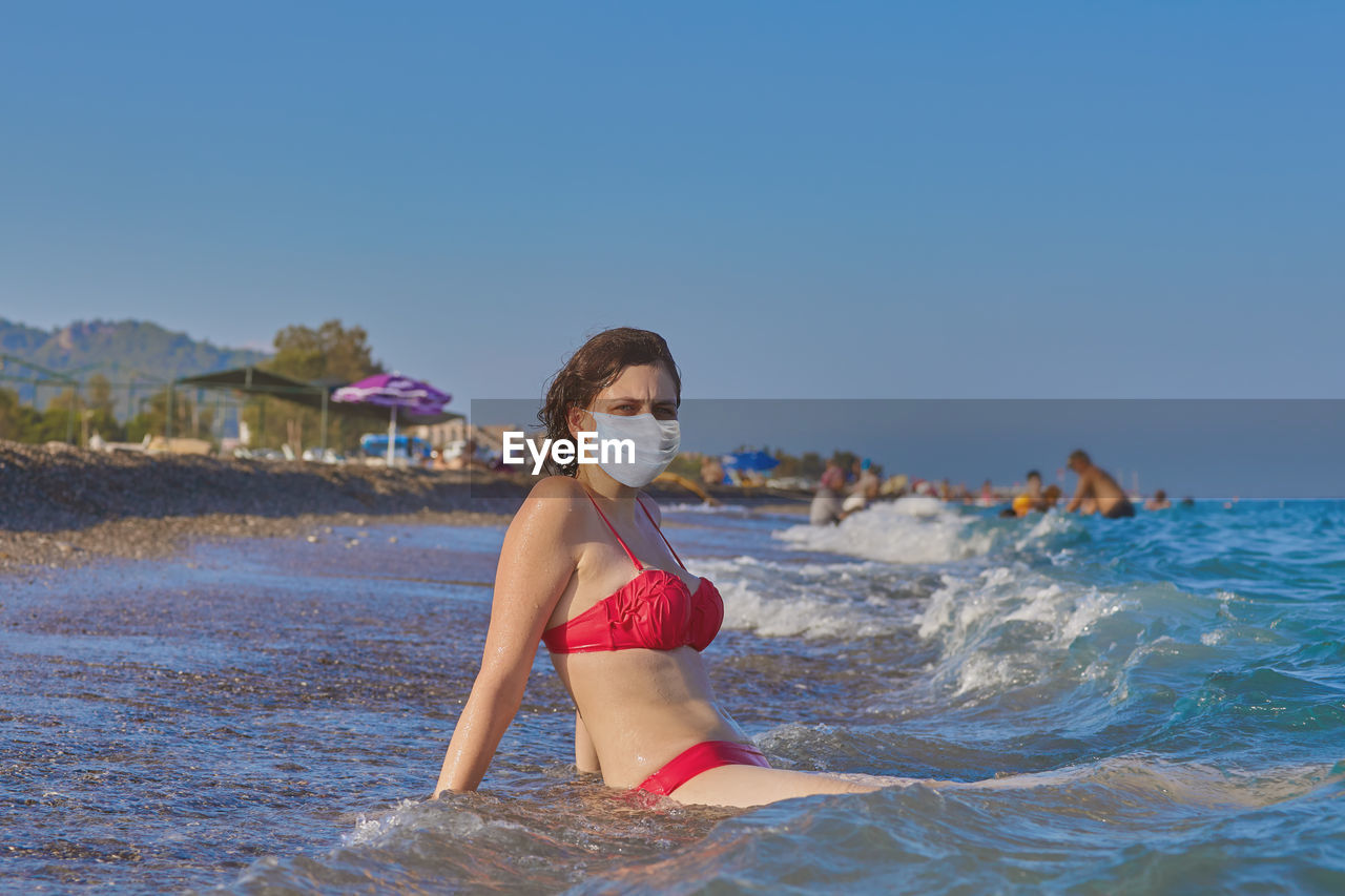 WOMAN WITH UMBRELLA ON BEACH