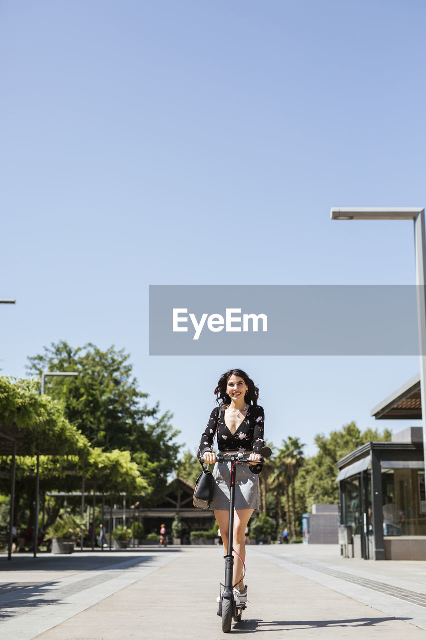 Young woman with e-scooter in the city