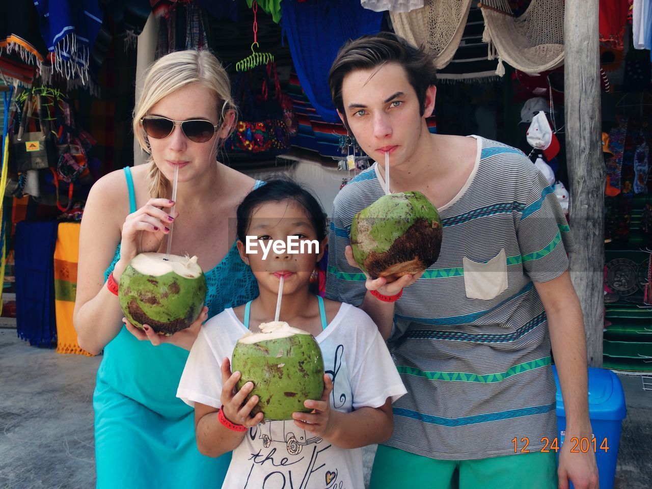 Portrait of family drinking coconut water in market